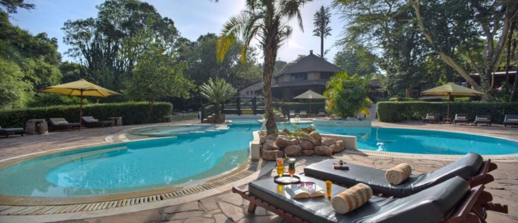 Het lagunevormige zwembad van het Sarova Mara Game Camp, rond een rotseilandje met een palmboom