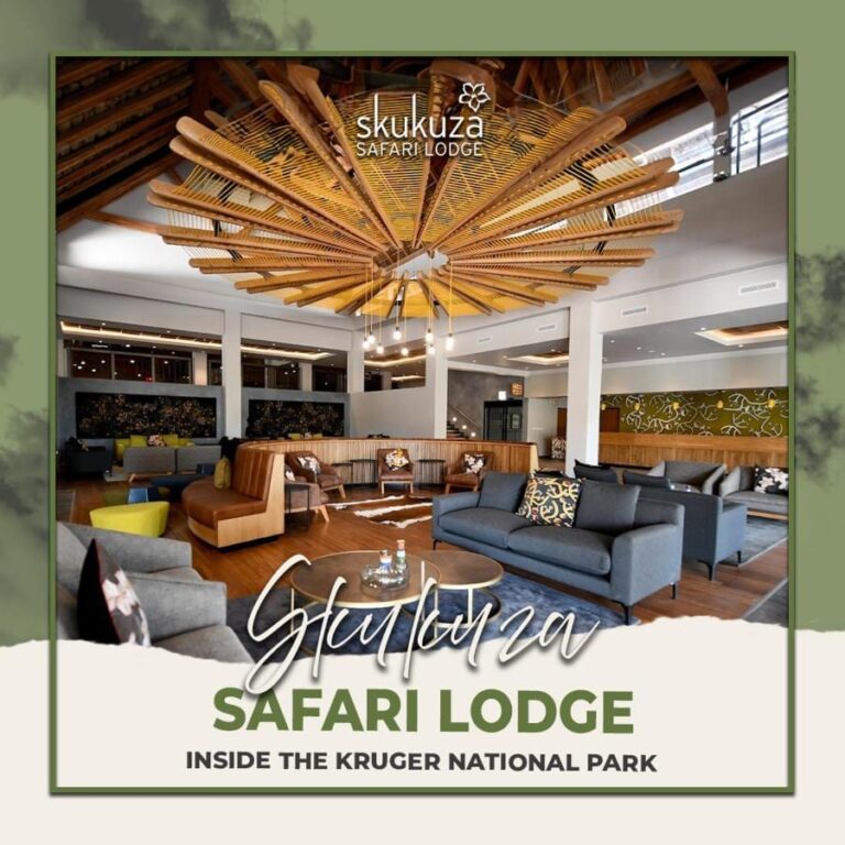 De lounge in de hal van de Skukuza Safari Lodge onder een stervormig plafond van houten latten, met de naam van de lodge eroverheen